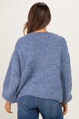 woman wearing a cozy blue knitted maternity sweater with balloon sleeves and a relaxed fit, seen from the back