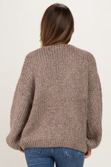 woman wearing a cozy brown chunky knit maternity sweater with a relaxed fit and balloon sleeves