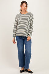 woman wearing a gray and white striped maternity top with long sleeves and blue wide-leg jeans, showing her baby bump