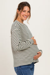 woman wearing a striped maternity top and holding her baby bump