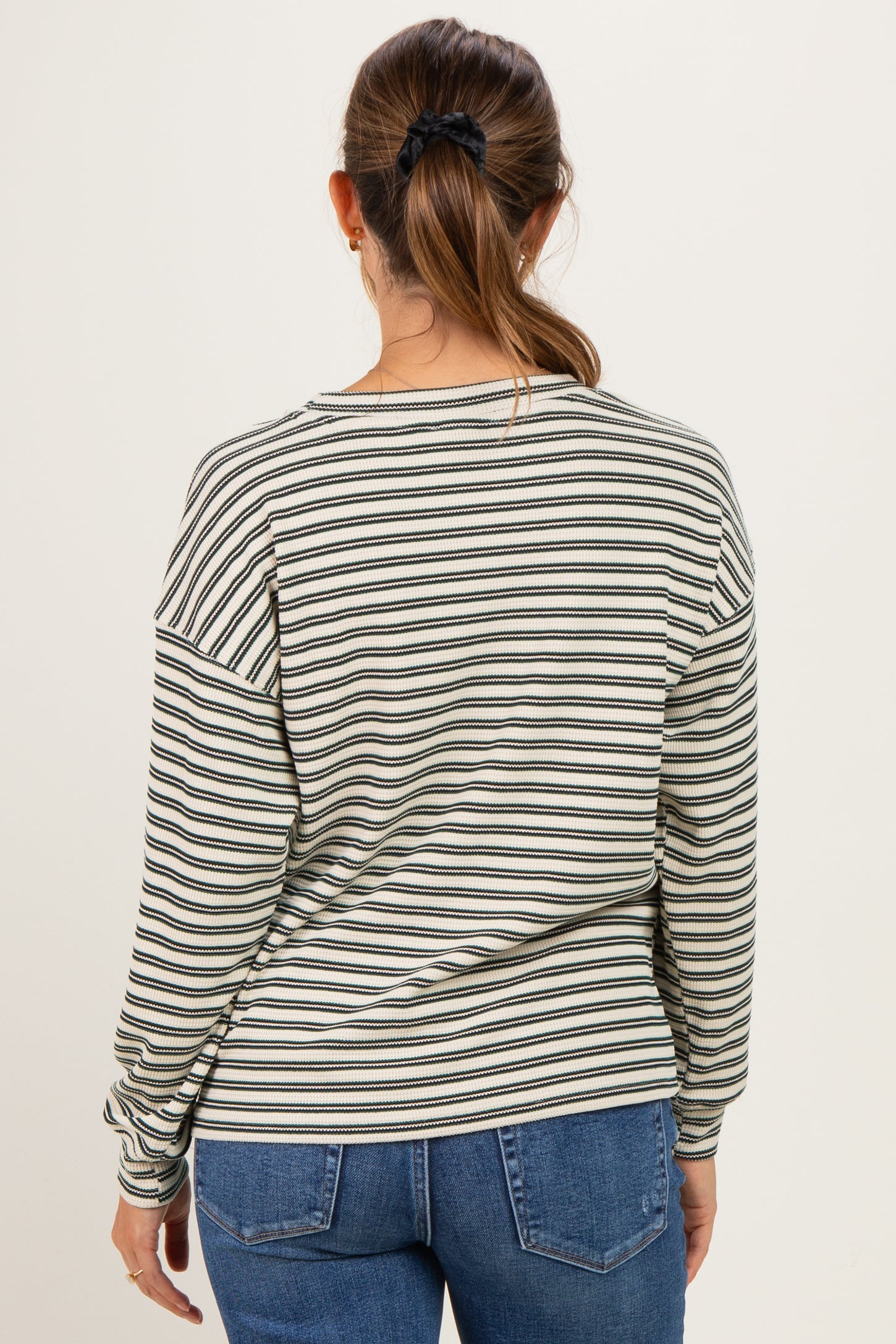 woman wearing a striped long sleeve maternity top, shown from the back with a relaxed fit and casual style