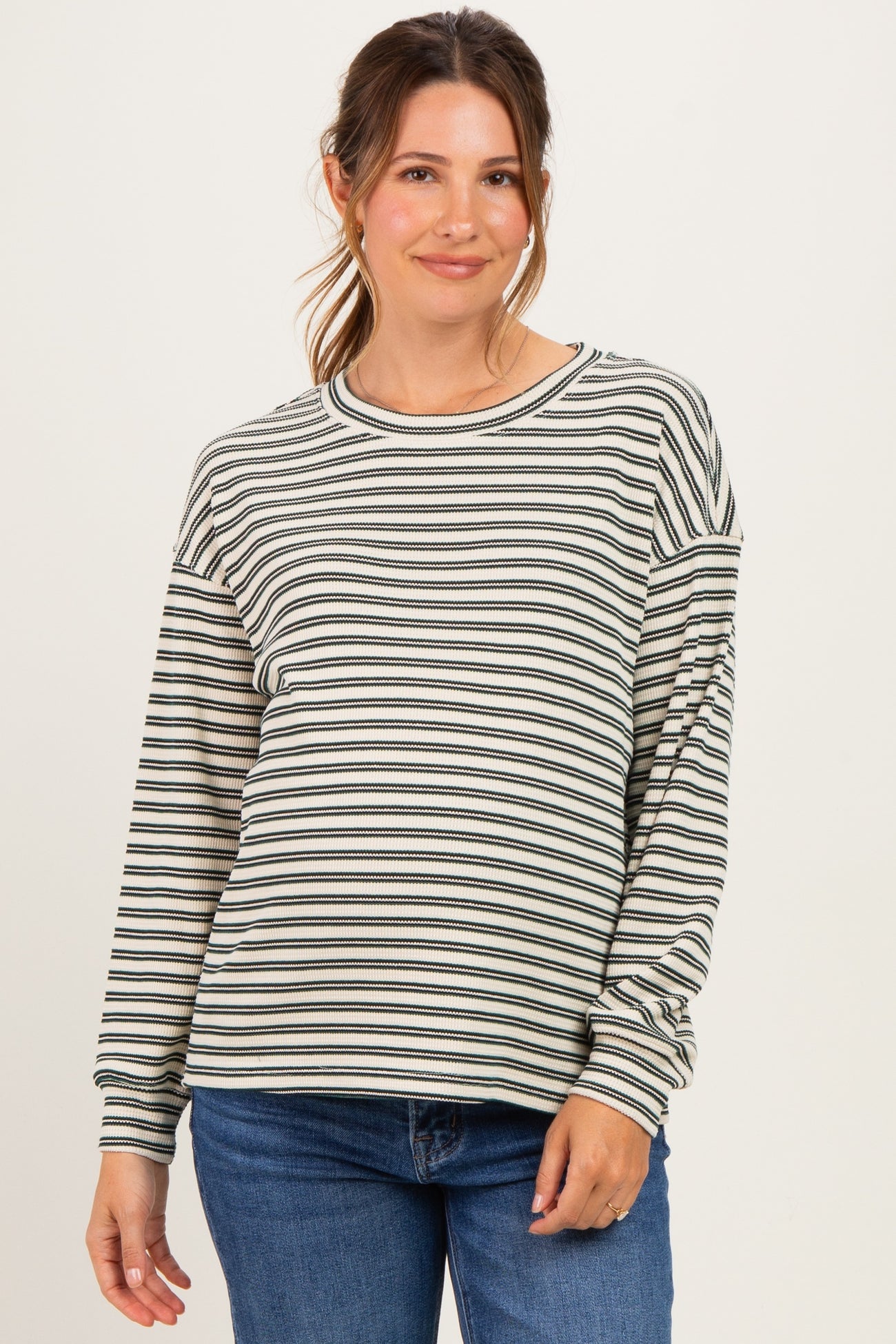 woman wearing a striped maternity long sleeve top with relaxed fit and cozy style, highlighting her baby bump
