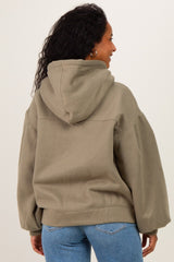 woman wearing a green oversized hoodie, showing off her baby bump with a relaxed fit and hooded design