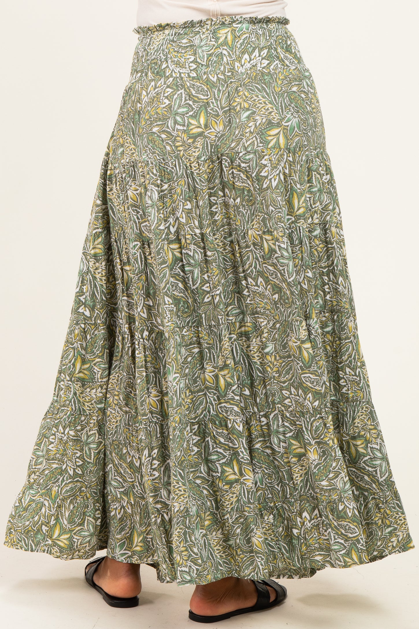 woman wearing a flowy green and yellow floral maxi skirt showing back view