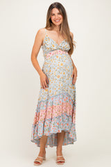 woman wearing a light blue floral print maternity dress with a high-low hem and a baby bump visible