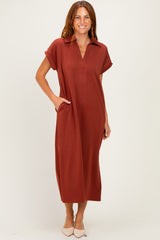 woman wearing a rust brown midi dress with a collared neckline and pockets