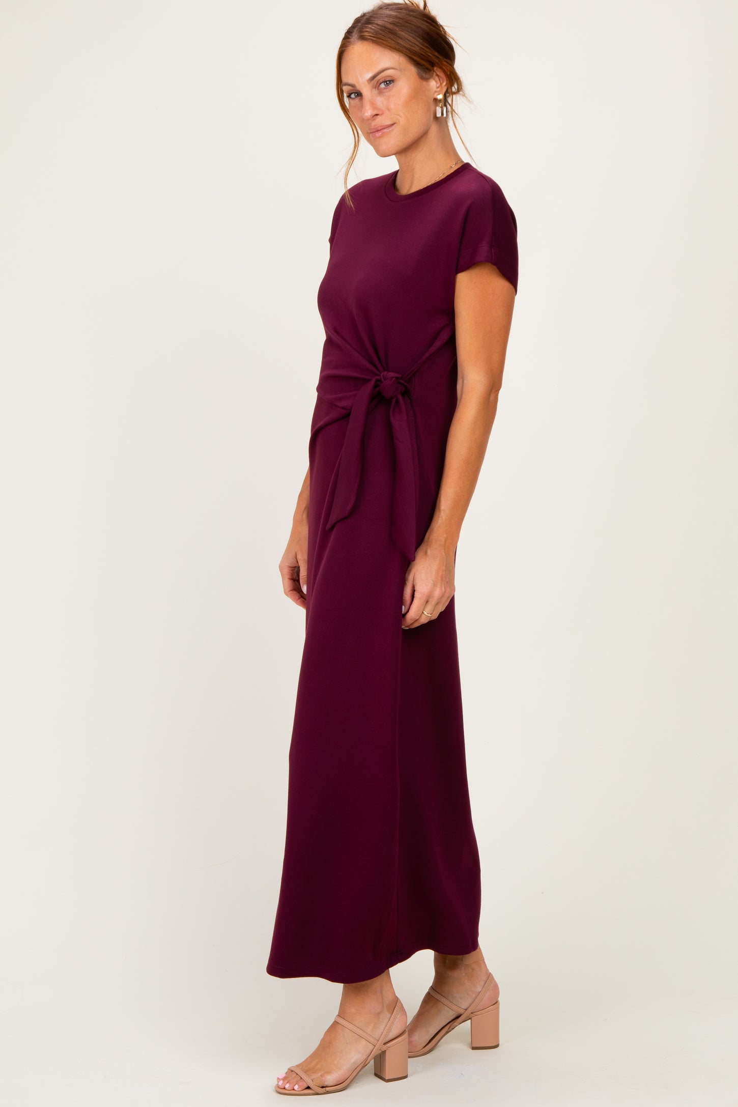 woman wearing a burgundy maxi dress with a tie waist detail and short sleeves