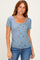 woman wearing a light blue short sleeve floral top and jeans