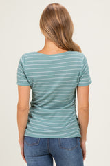 woman wearing a teal striped short sleeve top with a fitted silhouette and ruching detail on the sides