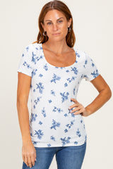 woman wearing a white short sleeve scoop neck top with blue floral print