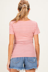woman wearing a pink striped maternity top with a fitted style and blue denim shorts