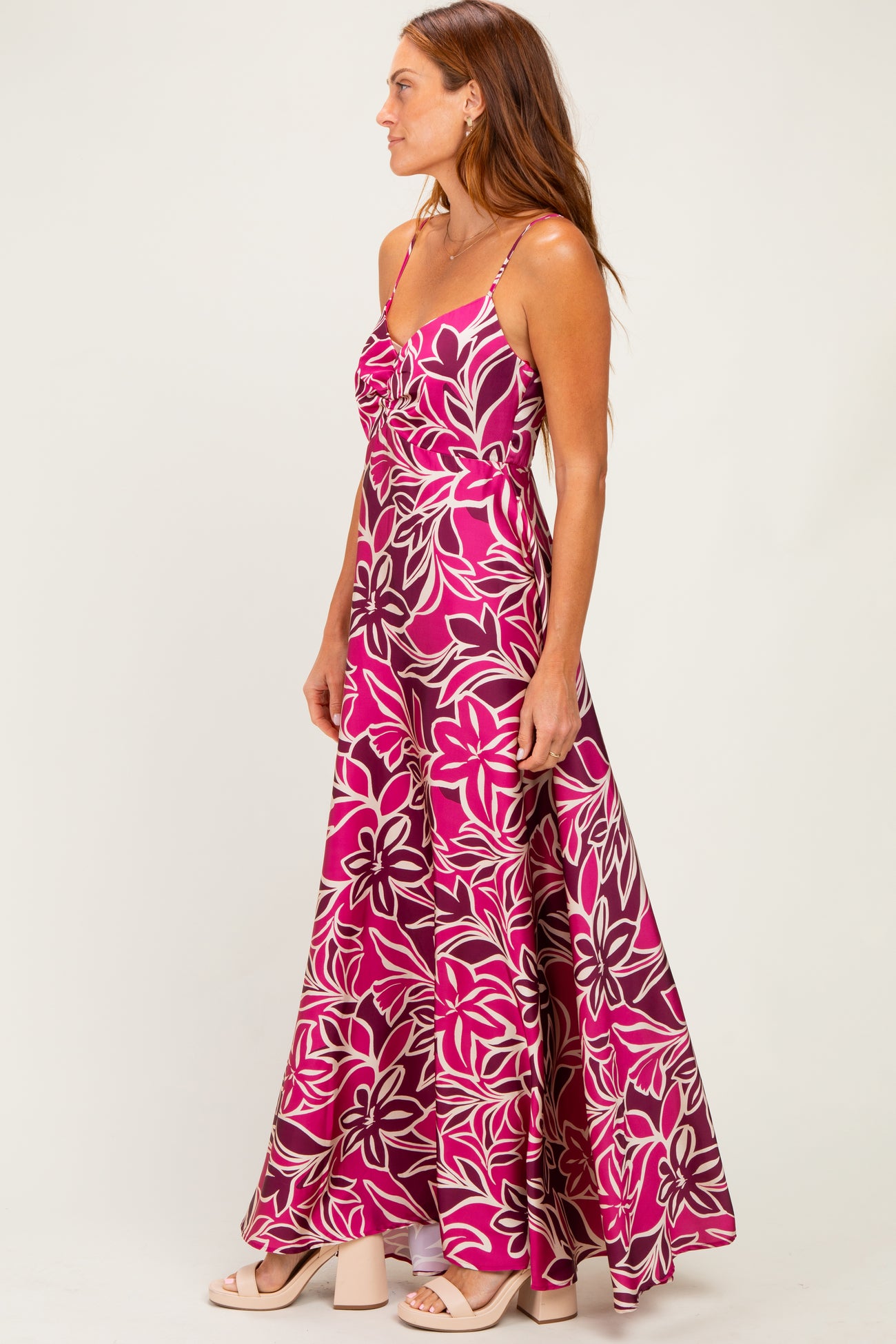 woman wearing a pink floral maxi dress with spaghetti straps and a flowing skirt