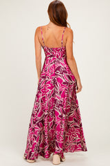 woman wearing a pink floral maxi dress with a flowy style and spaghetti straps, shown from the back