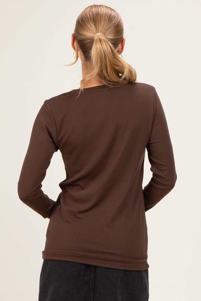 woman wearing a fitted brown long sleeve top, viewed from the back