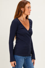 woman wearing a navy blue long sleeve wrap top paired with light blue jeans