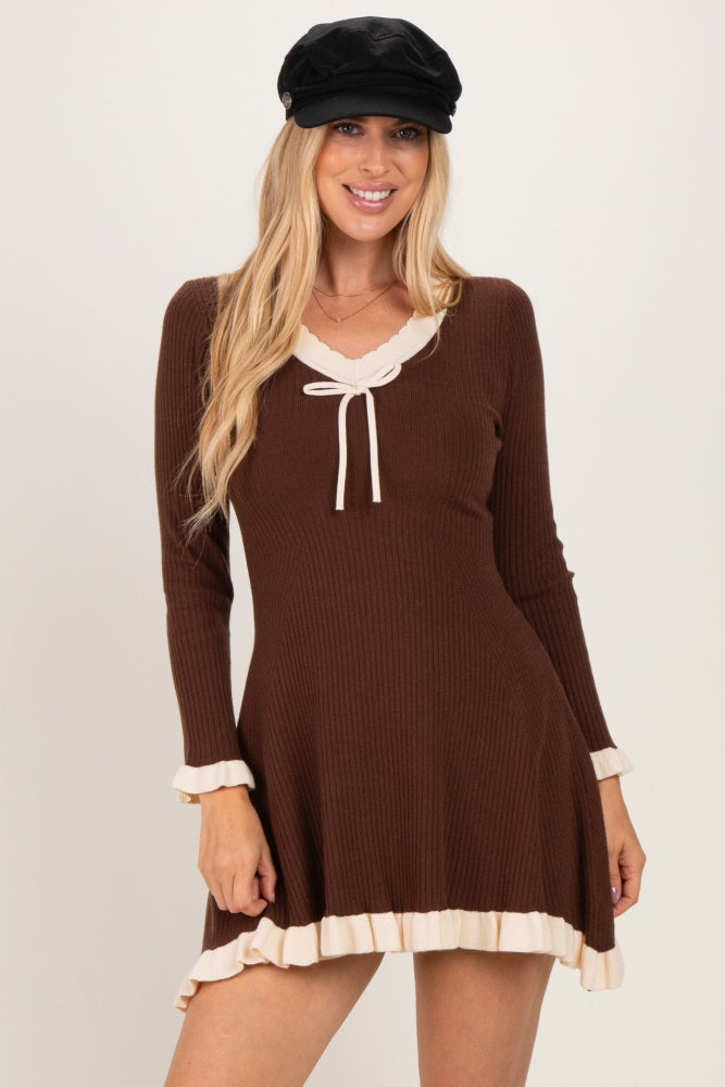 woman wearing a brown long sleeve ribbed dress with a scalloped neckline and ruffled hem details