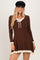 woman wearing a brown long sleeve ribbed dress with a scalloped neckline and ruffled hem details