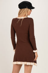 woman wearing a brown ribbed long sleeve dress with ruffled cream trim at the sleeves and hem