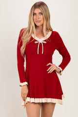 woman wearing a red long sleeve ribbed dress with a white neckline tie and ruffled hem