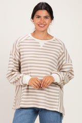 woman wearing a cream and beige striped oversized sweatshirt with a crew neckline and long sleeves