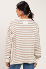 woman wearing a beige and cream striped oversized sweater, showing the back view with relaxed fit and long sleeves