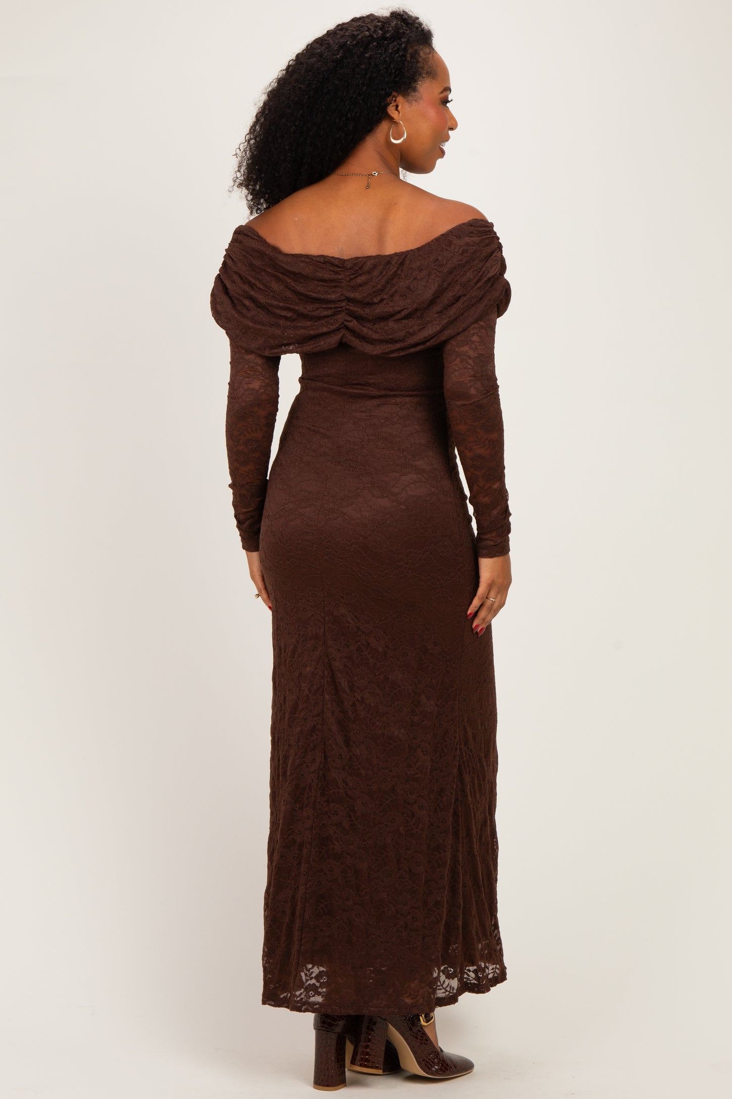 woman wearing a brown off-shoulder lace gown with long sleeves and a form-fitting silhouette, viewed from the back