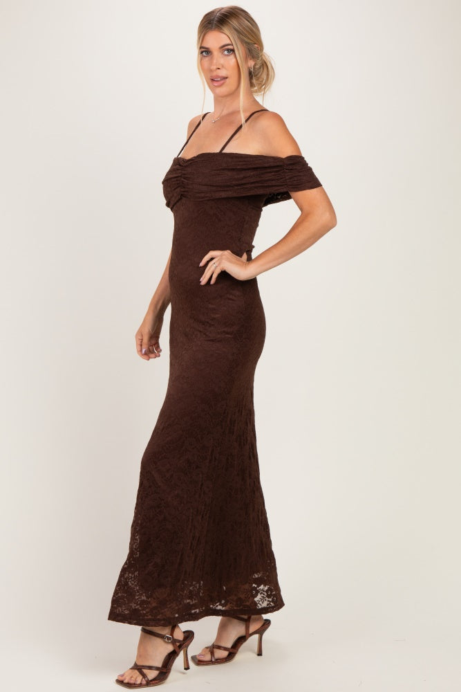 woman wearing a brown off-the-shoulder lace maxi dress with ruched detailing and strappy heels