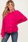 woman wearing a bright pink maternity cardigan with buttons and relaxed fit, paired with blue jeans