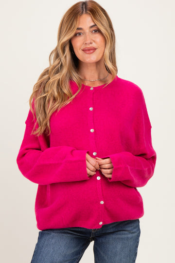 woman wearing a bright pink maternity cardigan with buttons, styled casually with jeans