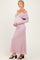 woman wearing a light pink off-the-shoulder lace maternity dress, gently cradling her baby bump