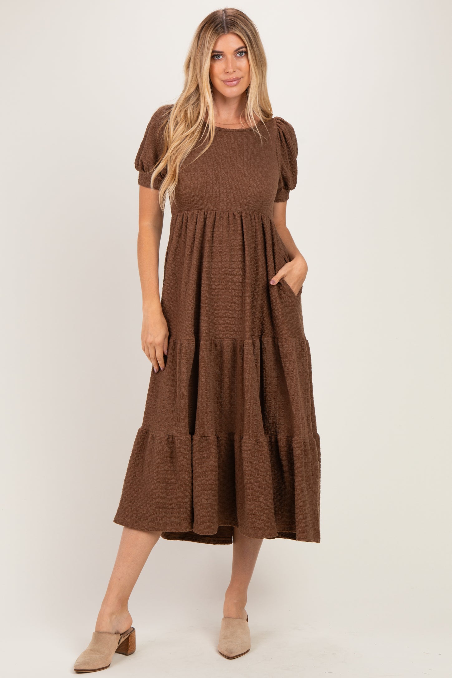 woman wearing a brown tiered maxi dress with puff sleeves and pockets