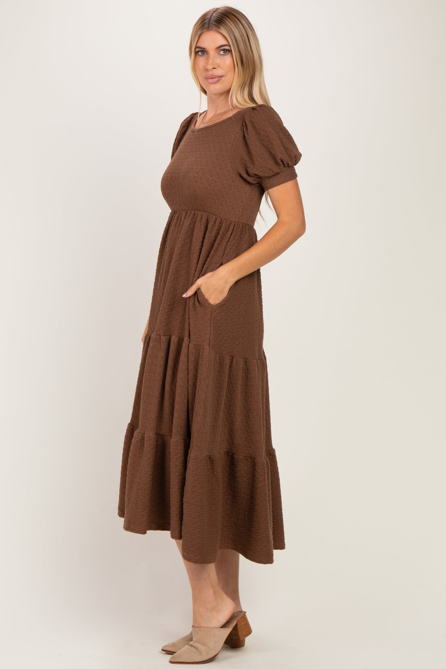 woman wearing a brown puff sleeve tiered midi dress with pockets and a relaxed fit