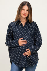 woman wearing a navy blue polka dot maternity shirt and holding her baby bump