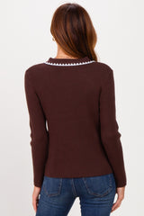 woman wearing a brown ribbed long sleeve sweater with a decorative collar, viewed from the back