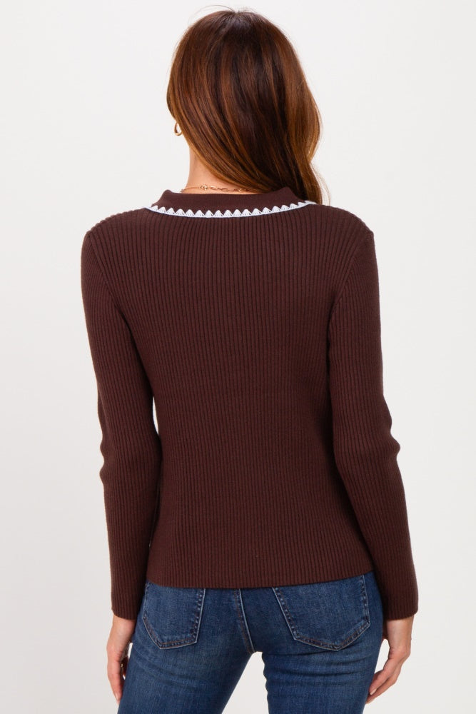 woman wearing a brown ribbed long sleeve sweater with a decorative collar, viewed from the back