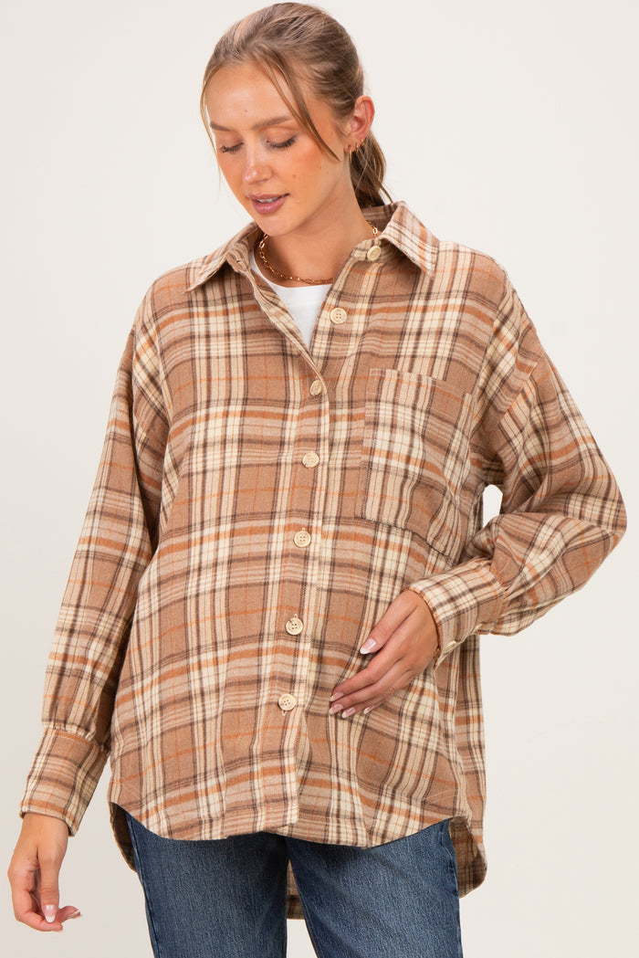 woman wearing a brown plaid maternity button-up shirt and gently resting her hand on her baby bump