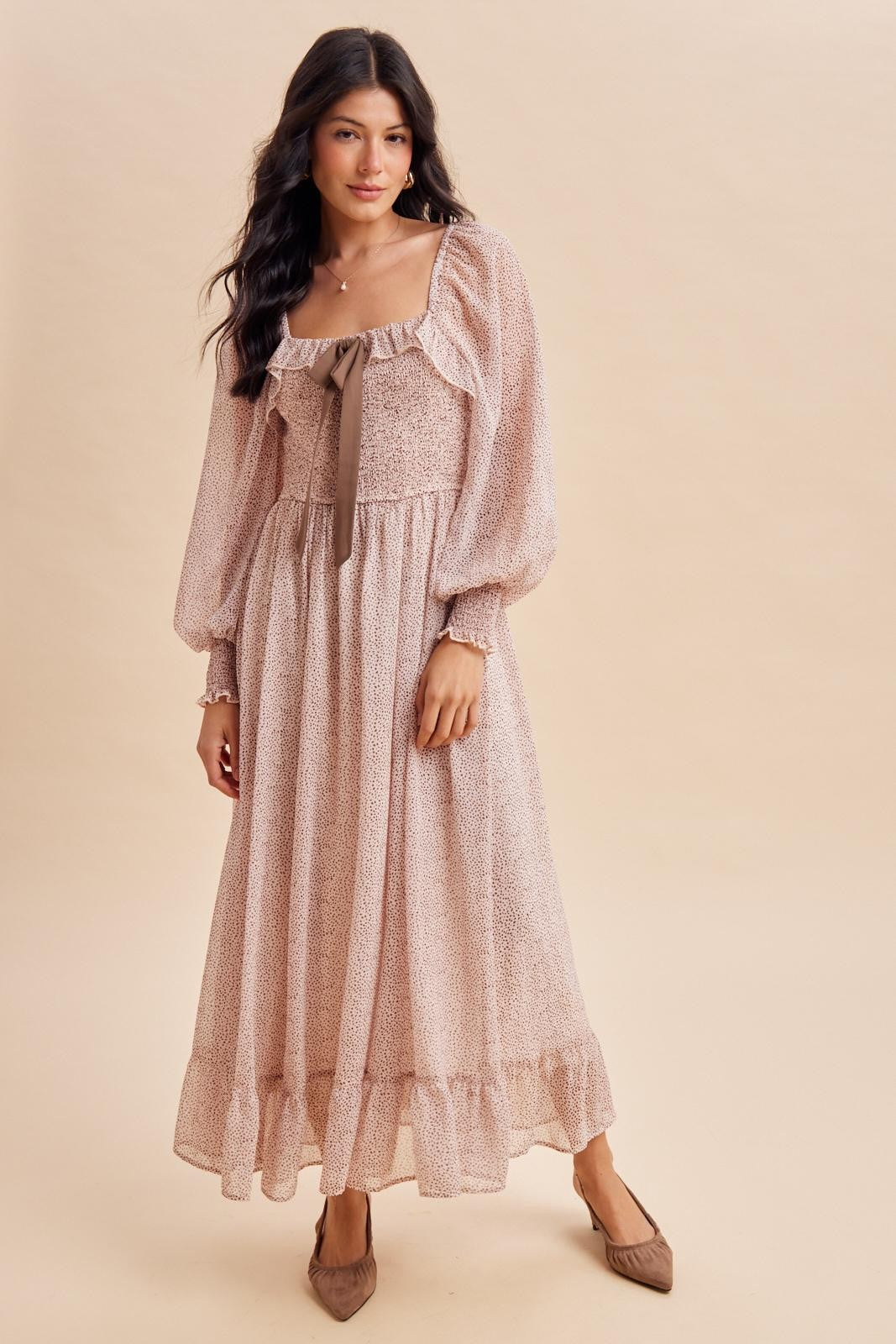 woman wearing a pink floral long sleeve maxi dress with a square neckline and bow detail