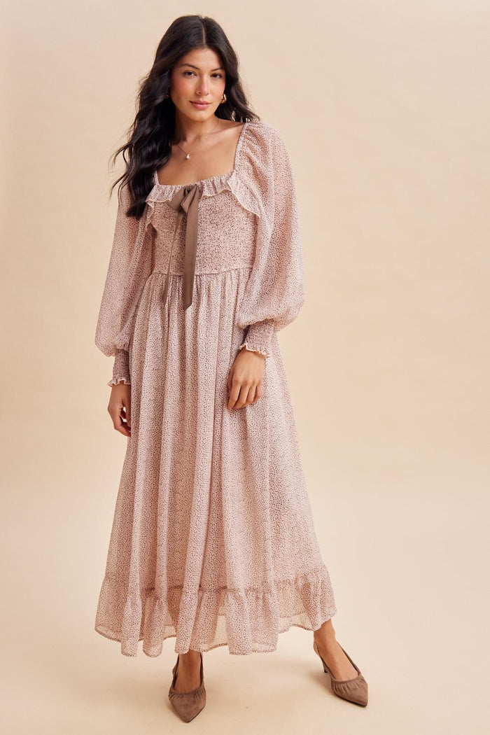 woman wearing a pink floral long sleeve maxi dress with a square neckline and bow detail