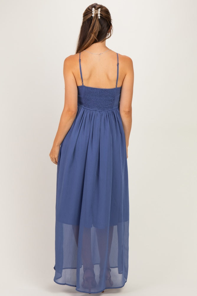 woman wearing a navy blue maternity maxi dress with a smocked back and adjustable straps