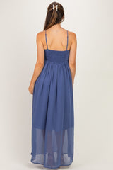 woman wearing a navy blue maternity maxi dress with a smocked back and adjustable straps