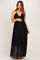 woman wearing a black maternity maxi dress with a sheer overlay and holding her baby bump