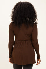 woman wearing a brown long sleeve ribbed top with a gathered waist, viewed from the back