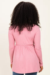 woman wearing a pink long sleeve ribbed tunic with a fitted waist and rounded hem, viewed from the back
