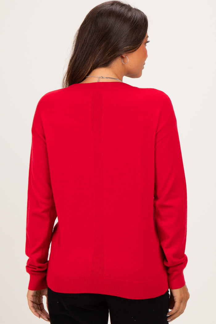 woman wearing a red maternity sweater, shown from the back with a relaxed fit and long sleeves