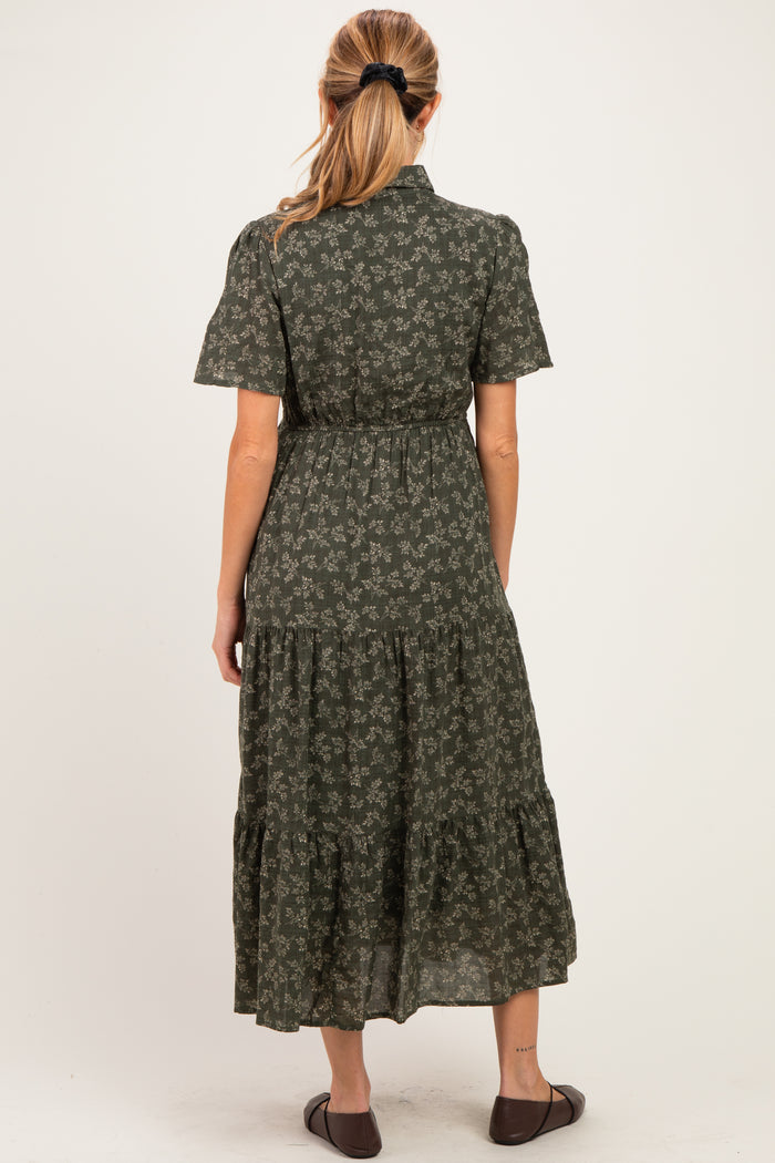 woman wearing a green floral maternity dress with short sleeves and a tiered skirt, showing a baby bump from the back