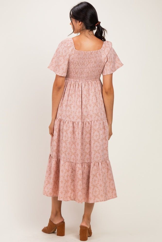 woman wearing a pink floral smocked tiered maxi dress with short sleeves and a square back