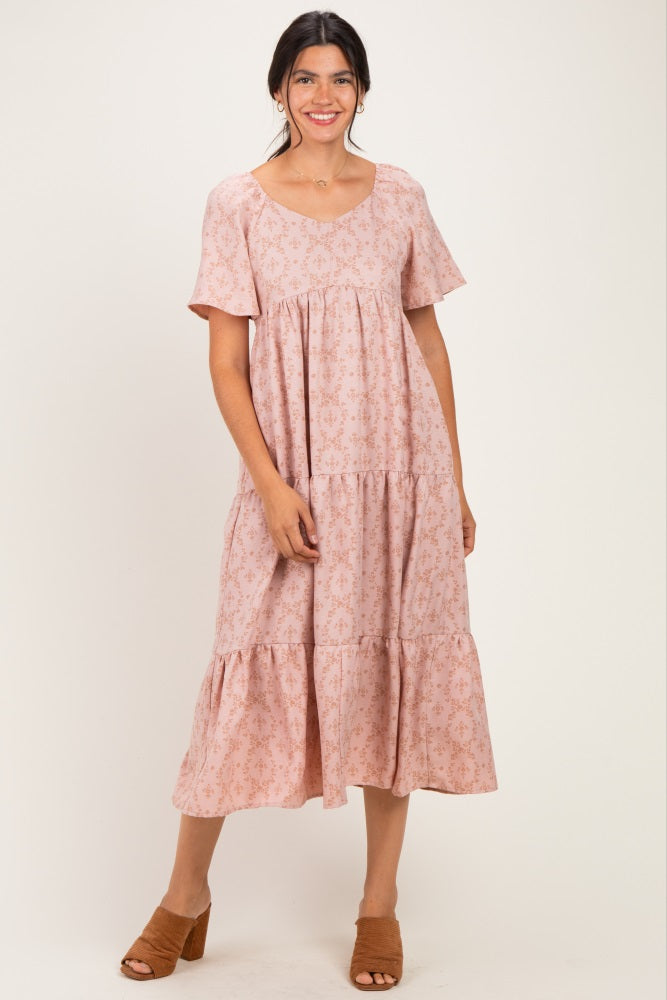 woman wearing a pink floral tiered midi dress with short sleeves and a scoop neckline