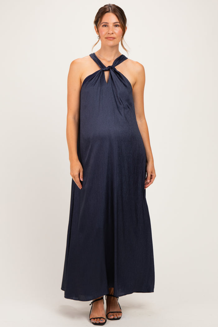 woman wearing a navy blue halter neck maternity maxi dress with a keyhole detail and visible baby bump