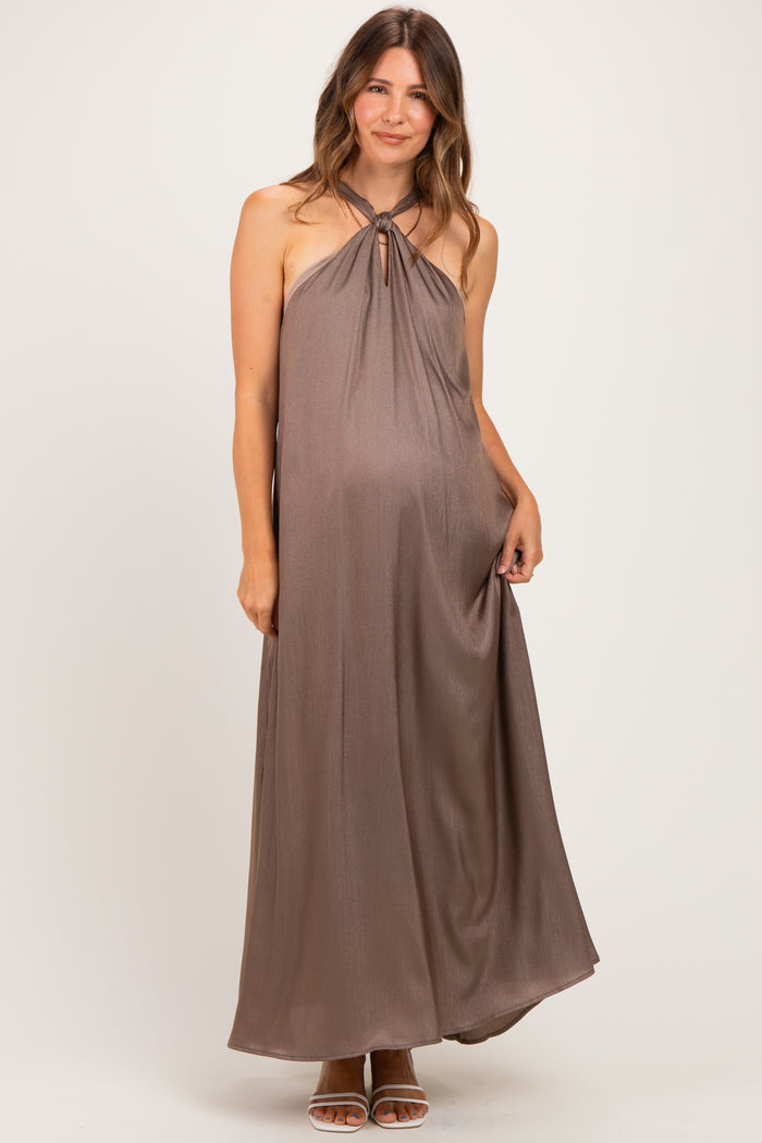 woman wearing a brown halter neck maxi maternity dress with a keyhole detail and a visible baby bump