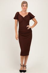 woman wearing a brown puff sleeve ruched midi dress with a sweetheart neckline and a bodycon fit